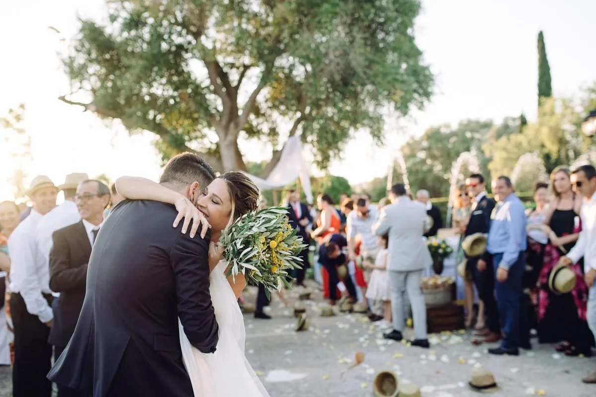 Novios abrazándose al final de la ceremonia, rodeados de invitados